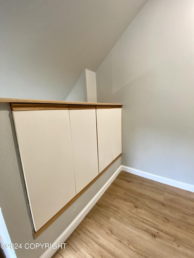 stairway featuring hardwood / wood-style flooring and vaulted ceiling