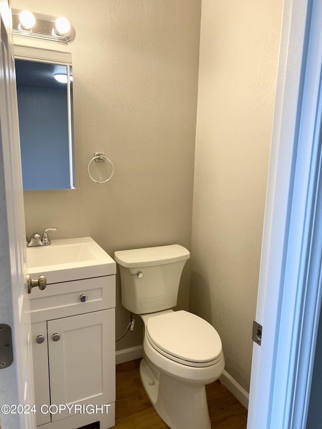 bathroom with hardwood / wood-style flooring, vanity, and toilet