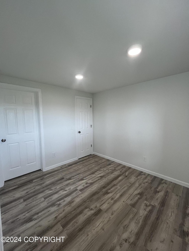 unfurnished bedroom with dark hardwood / wood-style flooring