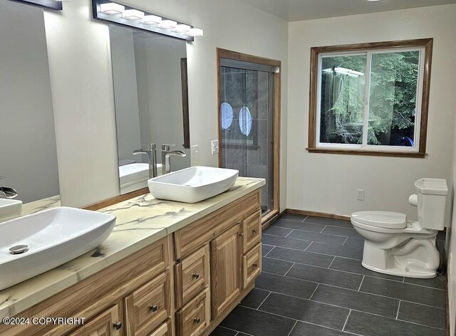 bathroom with a shower with door, vanity, and toilet