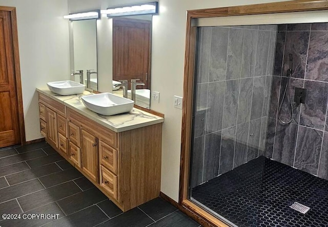 bathroom with vanity, a tile shower, and tile patterned flooring