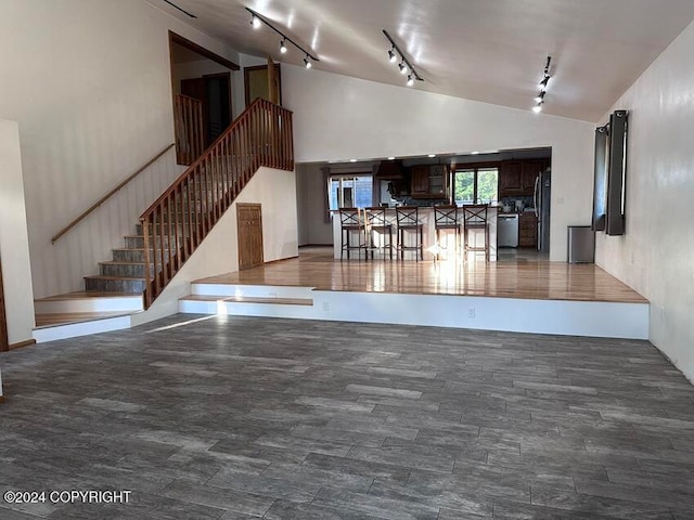 unfurnished living room with track lighting and high vaulted ceiling