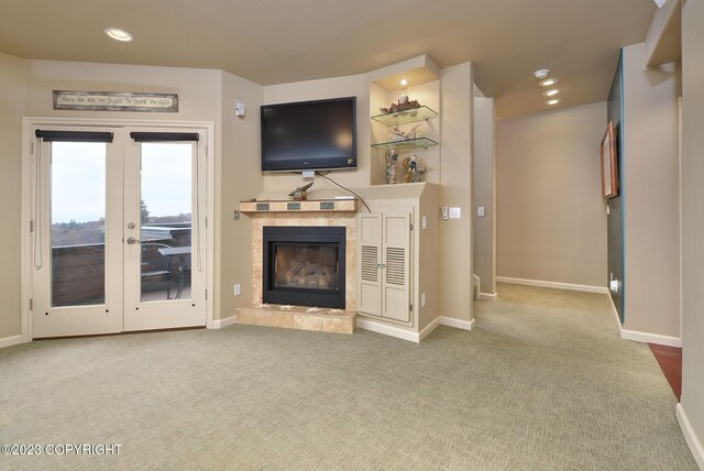 carpeted living room featuring a tiled fireplace and french doors