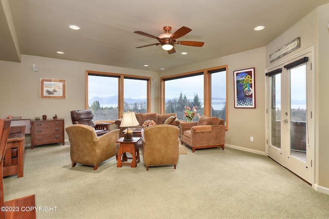 carpeted living room with french doors and ceiling fan