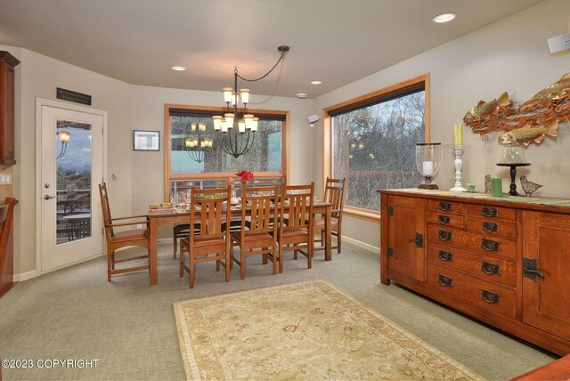 carpeted dining room featuring an inviting chandelier