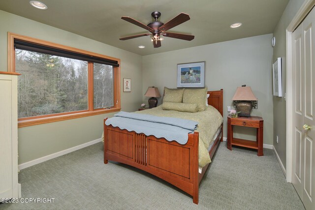 bedroom featuring light carpet, ceiling fan, and a closet