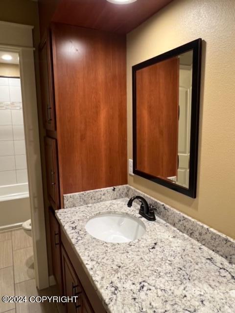 bathroom with tile patterned flooring, shower / bathtub combination, and vanity