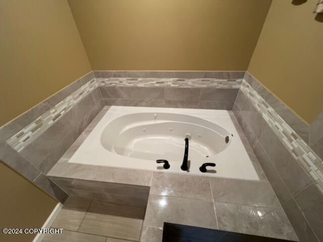 bathroom featuring tile patterned flooring and tiled bath