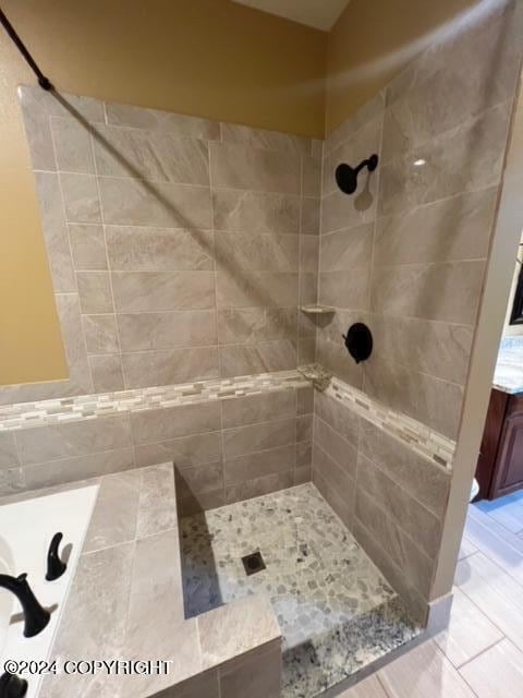 bathroom with a tile shower and tile patterned floors