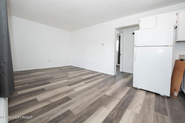 empty room with a textured ceiling and hardwood / wood-style flooring