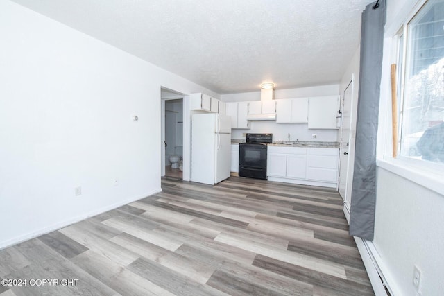 kitchen with white cabinetry, black range with electric cooktop, white fridge, and a textured ceiling