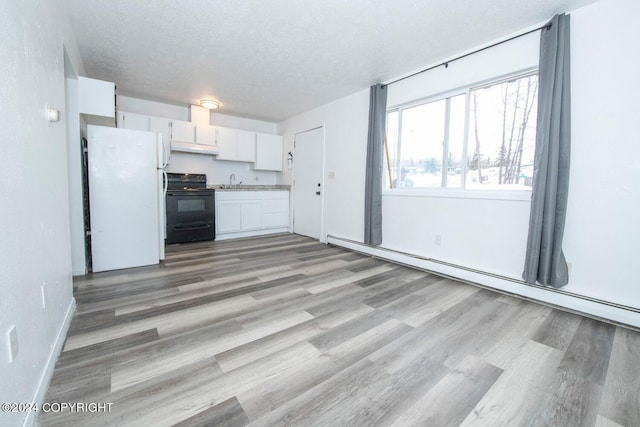 kitchen with white fridge, white cabinetry, a textured ceiling, light hardwood / wood-style floors, and black range with electric cooktop