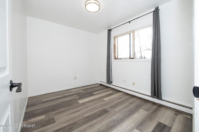 spare room with hardwood / wood-style floors and baseboard heating