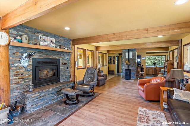 living room featuring beamed ceiling, hardwood / wood-style flooring, and a fireplace