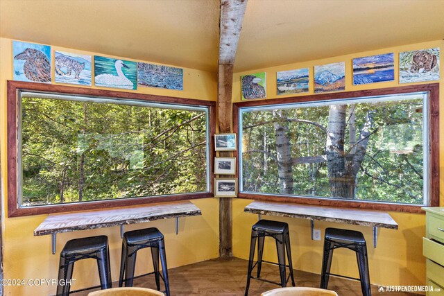 dining area with beamed ceiling and hardwood / wood-style flooring