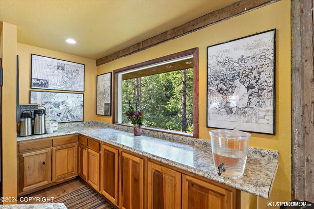 kitchen with light stone countertops and dark hardwood / wood-style flooring