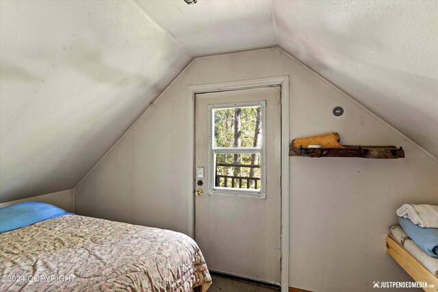 bedroom with vaulted ceiling and a textured ceiling