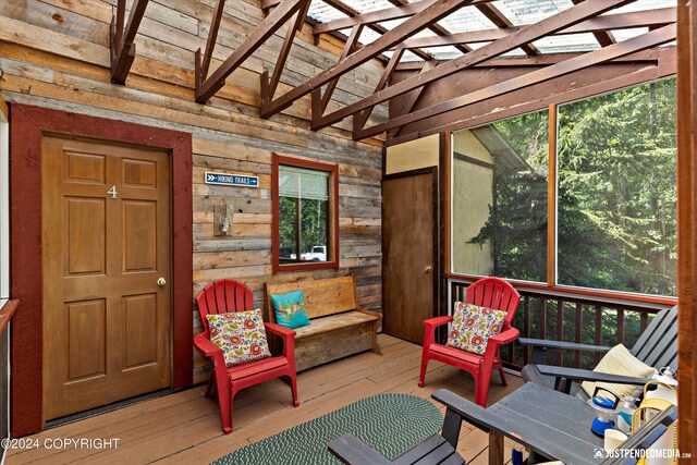 sunroom / solarium featuring lofted ceiling with beams and plenty of natural light