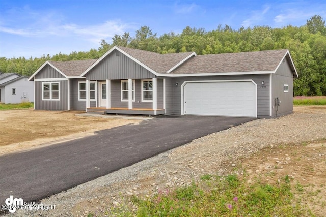 ranch-style house featuring a garage, aphalt driveway, and roof with shingles