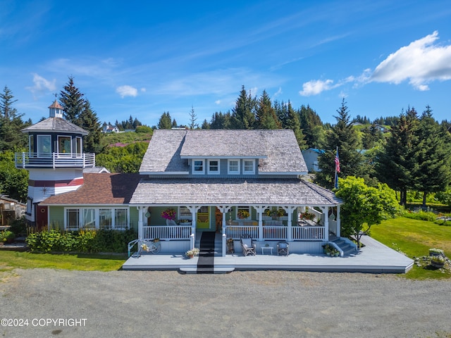 view of front facade with a wooden deck, a front lawn, a balcony, and a gazebo