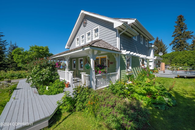 back of property featuring a lawn and covered porch