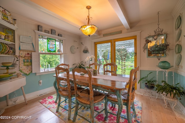 dining space with beamed ceiling, light wood-type flooring, and ornamental molding