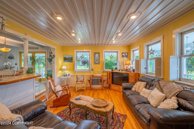 living room featuring light wood-type flooring and ornate columns