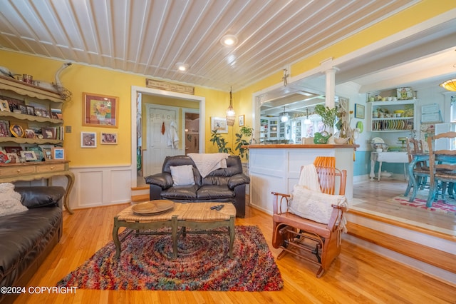 living room with light hardwood / wood-style flooring and decorative columns