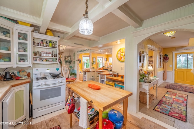 kitchen featuring crown molding, white range with gas cooktop, light hardwood / wood-style floors, beam ceiling, and decorative light fixtures