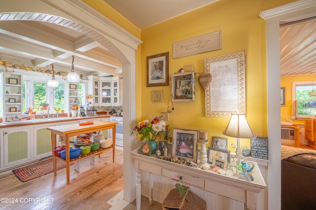 office space featuring light wood-type flooring, crown molding, and coffered ceiling