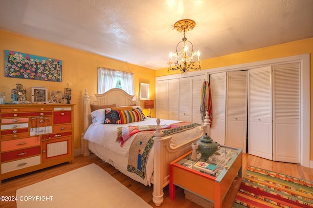 bedroom featuring two closets, a chandelier, and hardwood / wood-style floors