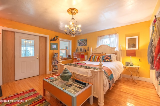 bedroom with an inviting chandelier and light hardwood / wood-style floors