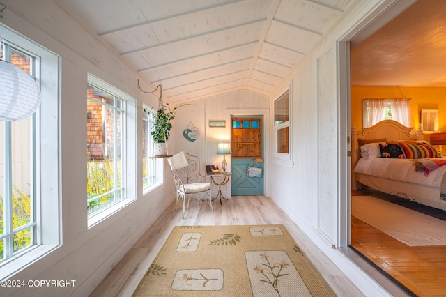 hall with light hardwood / wood-style flooring and vaulted ceiling