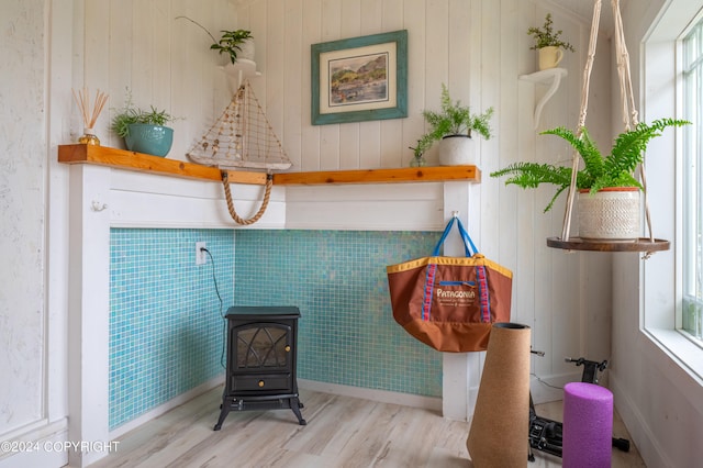 sitting room with a wood stove and light wood-type flooring