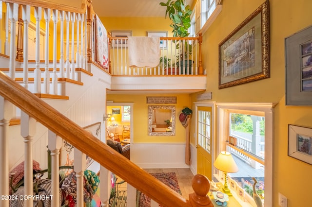 stairs featuring tile patterned floors and a towering ceiling