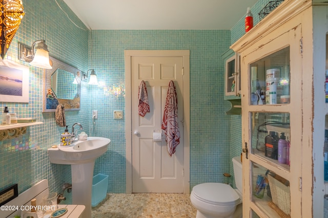 bathroom with tile walls, tile patterned floors, and toilet