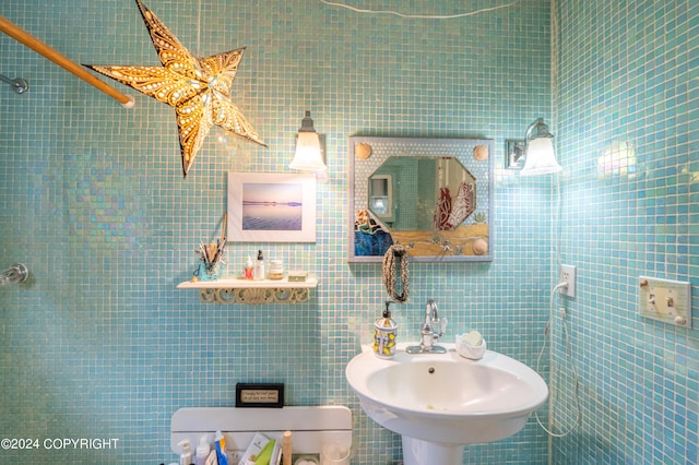 bathroom with tile walls and sink