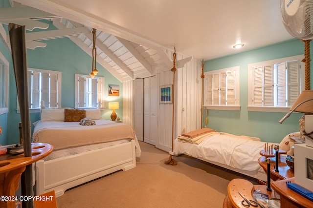 carpeted bedroom featuring lofted ceiling with beams