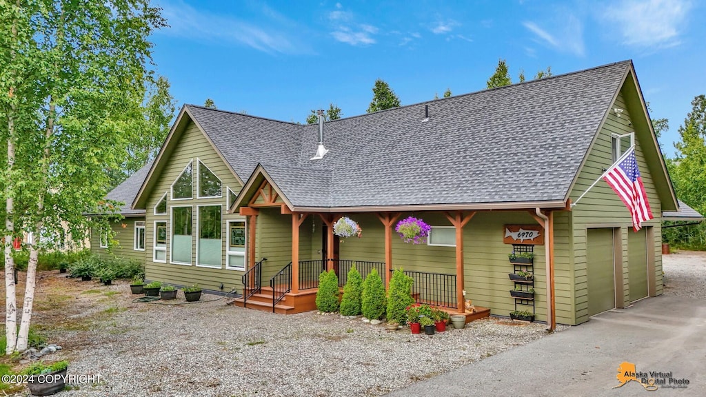 rustic home with a shingled roof and a detached garage