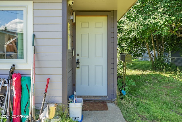 doorway to property with a lawn