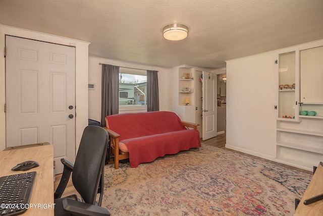 living room with a textured ceiling and light hardwood / wood-style floors