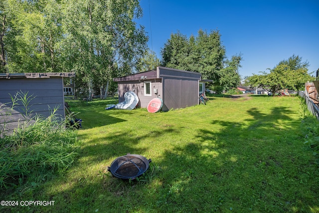 view of yard with an outdoor fire pit and a shed