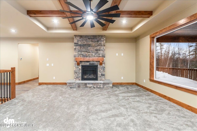 unfurnished living room with beamed ceiling, a fireplace, light wood-type flooring, and ceiling fan