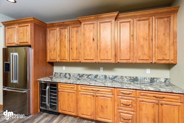 kitchen with high quality fridge, dark wood-type flooring, and light stone countertops