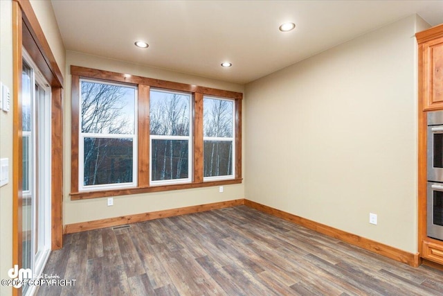 unfurnished room with wood-type flooring and a healthy amount of sunlight