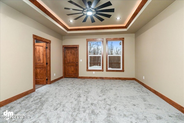 empty room with a tray ceiling and carpet floors