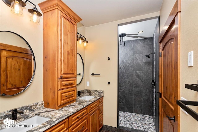 bathroom featuring a tile shower and double vanity