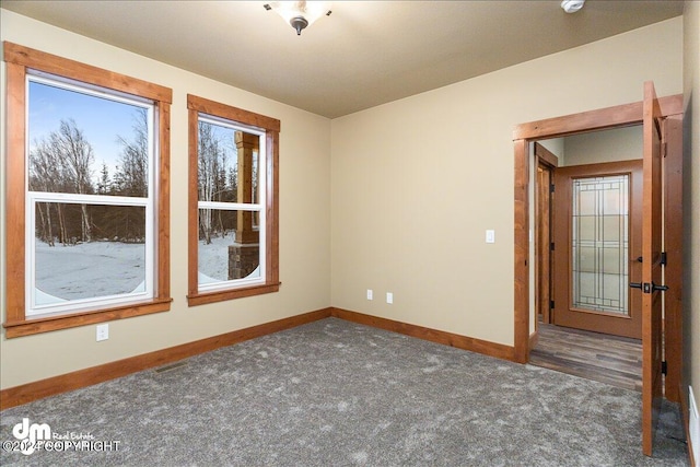 spare room featuring dark carpet