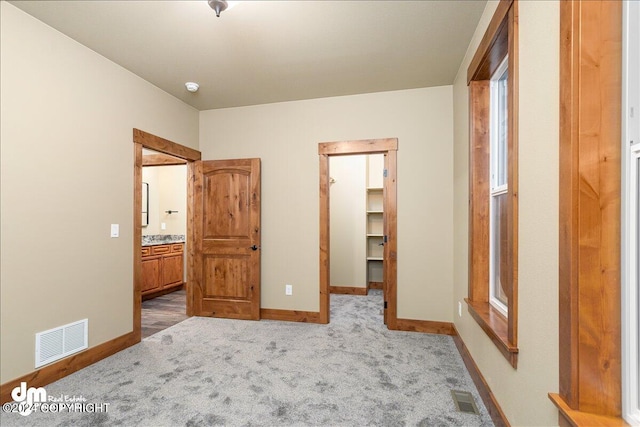 unfurnished bedroom featuring light hardwood / wood-style flooring, a closet, and a spacious closet