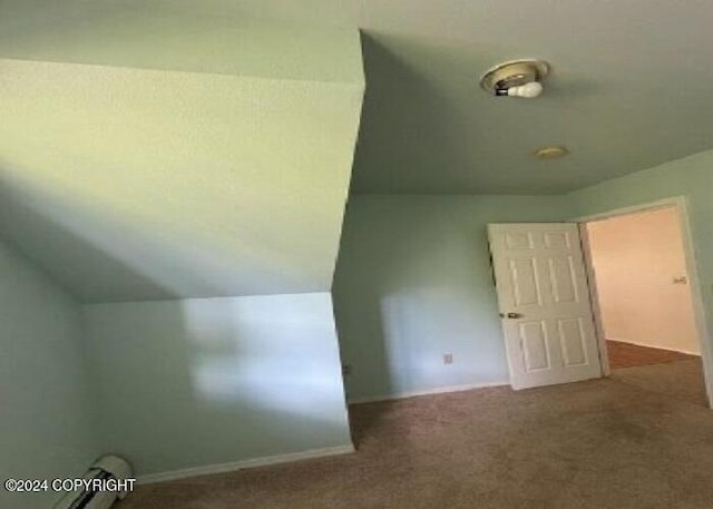 additional living space featuring vaulted ceiling, carpet, and baseboards